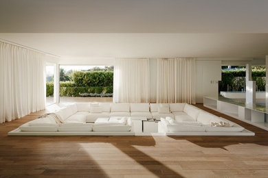 Esempio di un grande soggiorno design aperto con pareti bianche, pavimento in legno massello medio, nessun camino e nessuna TV