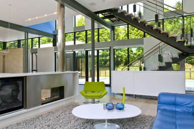 Cette image montre un salon design ouvert avec une cheminée double-face.