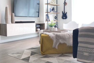 Foto de salón abierto minimalista de tamaño medio con paredes blancas, suelo de baldosas de porcelana, televisor colgado en la pared y suelo beige