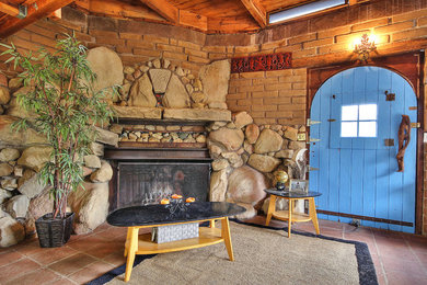 サンタバーバラにあるラスティックスタイルのおしゃれな応接間 (標準型暖炉、石材の暖炉まわり、テレビなし) の写真