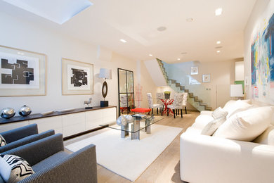 Foto di un soggiorno design aperto e di medie dimensioni con sala formale, pareti bianche, parquet chiaro e tappeto