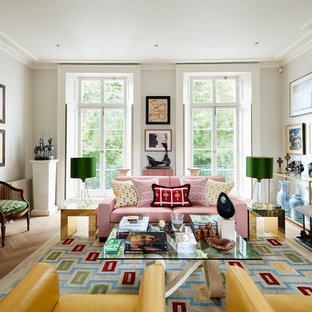Design ideas for a large bohemian living room in London with grey walls, medium hardwood flooring, a standard fireplace and brown floors.