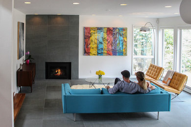 バーリントンにあるラグジュアリーな中くらいなコンテンポラリースタイルのおしゃれなリビング (白い壁、標準型暖炉、石材の暖炉まわり、青い床) の写真