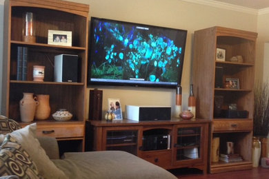 ダラスにあるトラディショナルスタイルのおしゃれなリビング (ベージュの壁、暖炉なし、壁掛け型テレビ、茶色い床) の写真