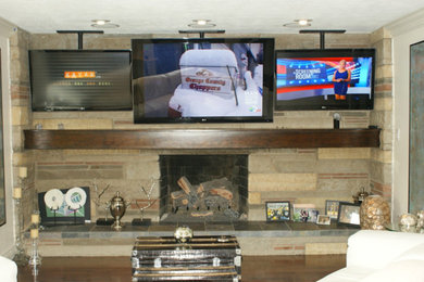 Foto de salón clásico con paredes blancas, marco de chimenea de ladrillo y televisor colgado en la pared