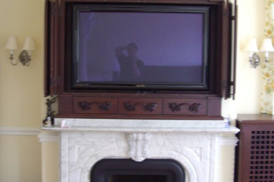 This is an example of a medium sized living room in Boston with yellow walls, a standard fireplace and a built-in media unit.