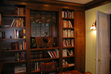 Example of a small classic enclosed living room library design in New York with yellow walls and no tv