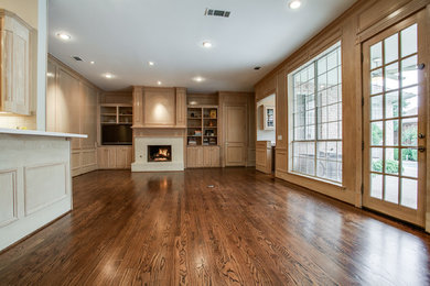 Mittelgroßes, Offenes Klassisches Wohnzimmer mit grauer Wandfarbe, dunklem Holzboden, Kamin, Kaminumrandung aus Stein, Multimediawand und braunem Boden in Dallas