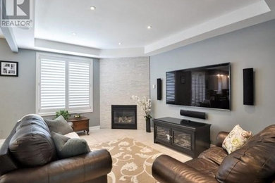 Example of a transitional open concept porcelain tile living room design in Toronto with gray walls, a corner fireplace and a stone fireplace