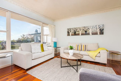 Kleines, Offenes Klassisches Wohnzimmer ohne Kamin mit grüner Wandfarbe und braunem Holzboden in Auckland