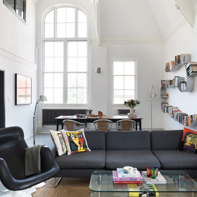 Urban open concept concrete floor living room library photo in London with white walls and no fireplace