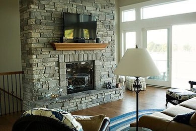 Living room - dark wood floor living room idea in Other with a stone fireplace