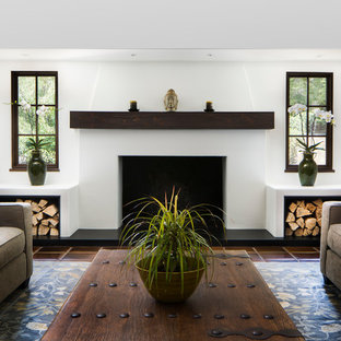 Mittelgroßes, Abgetrenntes Mediterranes Wohnzimmer mit weißer Wandfarbe, Terrakottaboden, Kamin, verputzter Kaminumrandung und braunem Boden in Santa Barbara