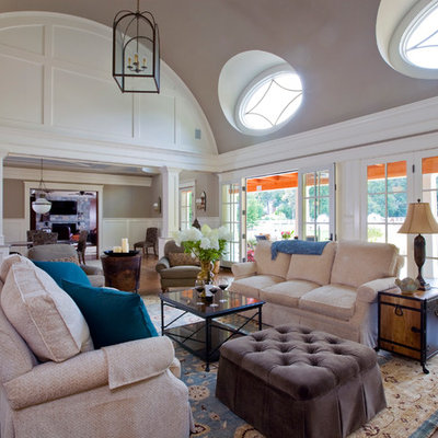 Inspiration for a large timeless formal and open concept medium tone wood floor living room remodel in Baltimore with gray walls, a wall-mounted tv, a standard fireplace and a plaster fireplace