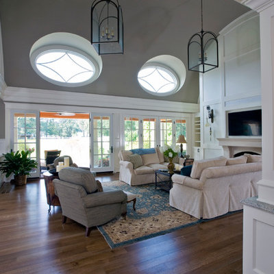 Inspiration for a large timeless formal and open concept medium tone wood floor living room remodel in Baltimore with gray walls, a standard fireplace, a plaster fireplace and a wall-mounted tv
