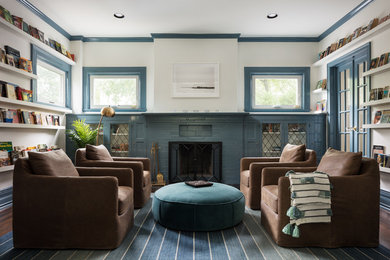 Inspiration for a large coastal enclosed dark wood floor and brown floor living room library remodel in New York with white walls, a standard fireplace and a brick fireplace