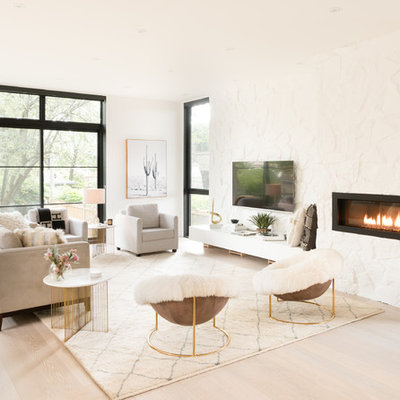 Living room - scandinavian open concept light wood floor and beige floor living room idea in Toronto with white walls, a ribbon fireplace, a stone fireplace and a wall-mounted tv