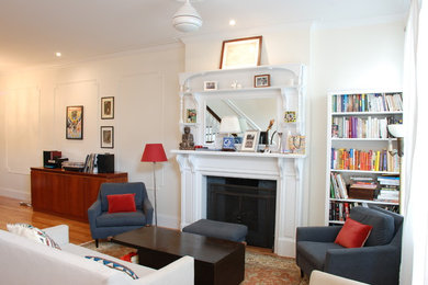 Стильный дизайн: открытая гостиная комната в классическом стиле с с книжными шкафами и полками, белыми стенами, светлым паркетным полом, стандартным камином и фасадом камина из дерева - последний тренд