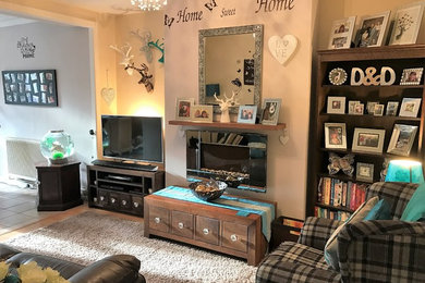 Kleines, Repräsentatives, Offenes Stilmix Wohnzimmer mit bunten Wänden, Laminat, Hängekamin und freistehendem TV in Hampshire