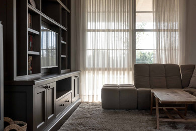 Cette photo montre un salon mansardé ou avec mezzanine montagne avec un bar de salon, un mur beige, parquet foncé, un poêle à bois, un manteau de cheminée en métal, un téléviseur encastré et un sol marron.