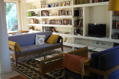 Foto di un soggiorno boho chic di medie dimensioni e aperto con libreria, pareti bianche, parquet chiaro, nessun camino e parete attrezzata