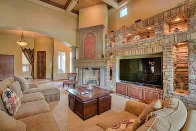 Example of a large southwest formal and open concept limestone floor living room design in Albuquerque with beige walls, a standard fireplace, a stone fireplace and a media wall