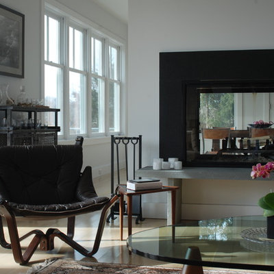Trendy living room photo in New York with a two-sided fireplace and white walls