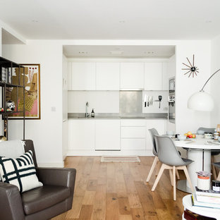 Inspiration för små nordiska allrum med öppen planlösning, med ett bibliotek, vita väggar, laminatgolv och en fristående TV