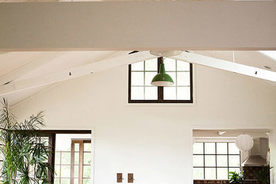 Ejemplo de salón abierto rústico de tamaño medio sin chimenea con paredes blancas y suelo de bambú