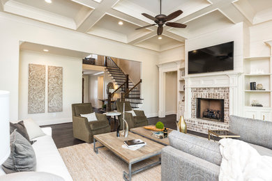 Photo of a medium sized classic formal open plan living room in Birmingham with white walls, dark hardwood flooring, a standard fireplace, a brick fireplace surround, a wall mounted tv and brown floors.