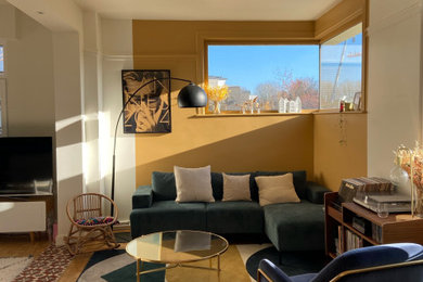 Modelo de salón abierto minimalista con paredes amarillas y suelo de madera clara