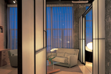 Diseño de salón abierto urbano de tamaño medio con paredes grises y suelo de madera clara