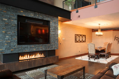 Large urban loft-style concrete floor living room photo in Wichita with beige walls, a ribbon fireplace, a metal fireplace and a wall-mounted tv