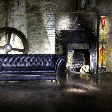 Industrial living room with distressed black leather chesterfield