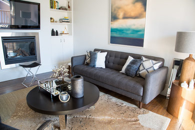 Esempio di un piccolo soggiorno moderno aperto con pareti bianche e pavimento in legno massello medio
