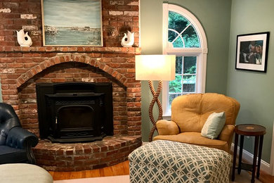 Example of a beach style carpeted and beige floor living room design in Other with blue walls, a wood stove and a brick fireplace