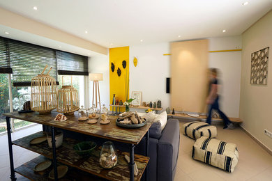 他の地域にある中くらいなシャビーシック調のおしゃれな独立型リビング (黄色い壁、薪ストーブ、金属の暖炉まわり、ベージュの床) の写真