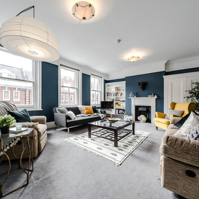 Example of a transitional carpeted living room design in London with blue walls and a standard fireplace