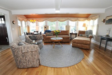 Modelo de salón para visitas abierto clásico grande sin chimenea y televisor con suelo de madera en tonos medios, paredes grises y suelo marrón