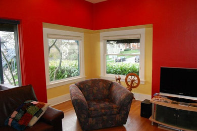 Inspiration for a mid-sized contemporary enclosed medium tone wood floor living room remodel in Seattle with red walls and a tv stand