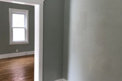 Ejemplo de salón abierto de estilo americano de tamaño medio sin televisor con paredes grises, suelo de madera en tonos medios y suelo marrón