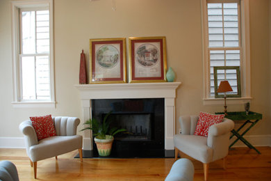 Example of a mid-sized medium tone wood floor living room design in Atlanta with beige walls, a standard fireplace and a wood fireplace surround