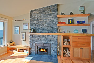 Example of a classic medium tone wood floor living room design in Seattle with gray walls, a standard fireplace and a stone fireplace