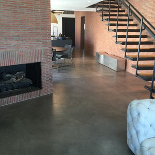 Großes, Repräsentatives Industrial Wohnzimmer im Loft-Stil mit roter Wandfarbe, Betonboden, Kamin, Kaminumrandung aus Backstein und grauem Boden in Los Angeles