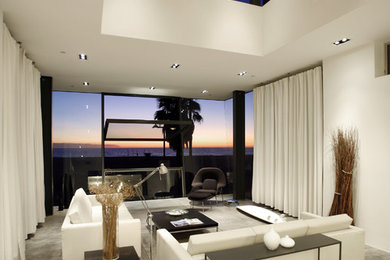 Стильный дизайн: гостиная комната в стиле модернизм с белыми стенами и бетонным полом - последний тренд