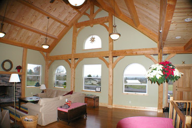 Diseño de salón abierto tradicional de tamaño medio con suelo de madera en tonos medios, todas las chimeneas y marco de chimenea de piedra