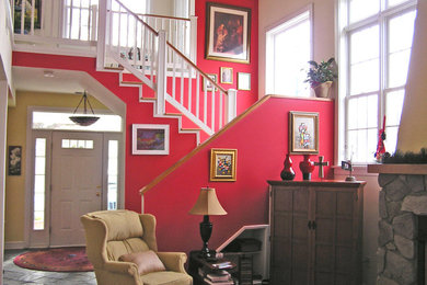 ワシントンD.C.にある低価格の中くらいなトラディショナルスタイルのおしゃれなリビング (赤い壁、スレートの床、標準型暖炉、石材の暖炉まわり、テレビなし、グレーの床) の写真