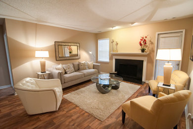 Photo of a large contemporary formal enclosed living room in Birmingham with beige walls, dark hardwood flooring, a standard fireplace, a plastered fireplace surround and no tv.