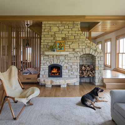 Example of a cottage medium tone wood floor living room design in Minneapolis with white walls and a standard fireplace