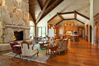 Living room - huge mediterranean open concept dark wood floor living room idea in San Luis Obispo with white walls, a standard fireplace and a stone fireplace